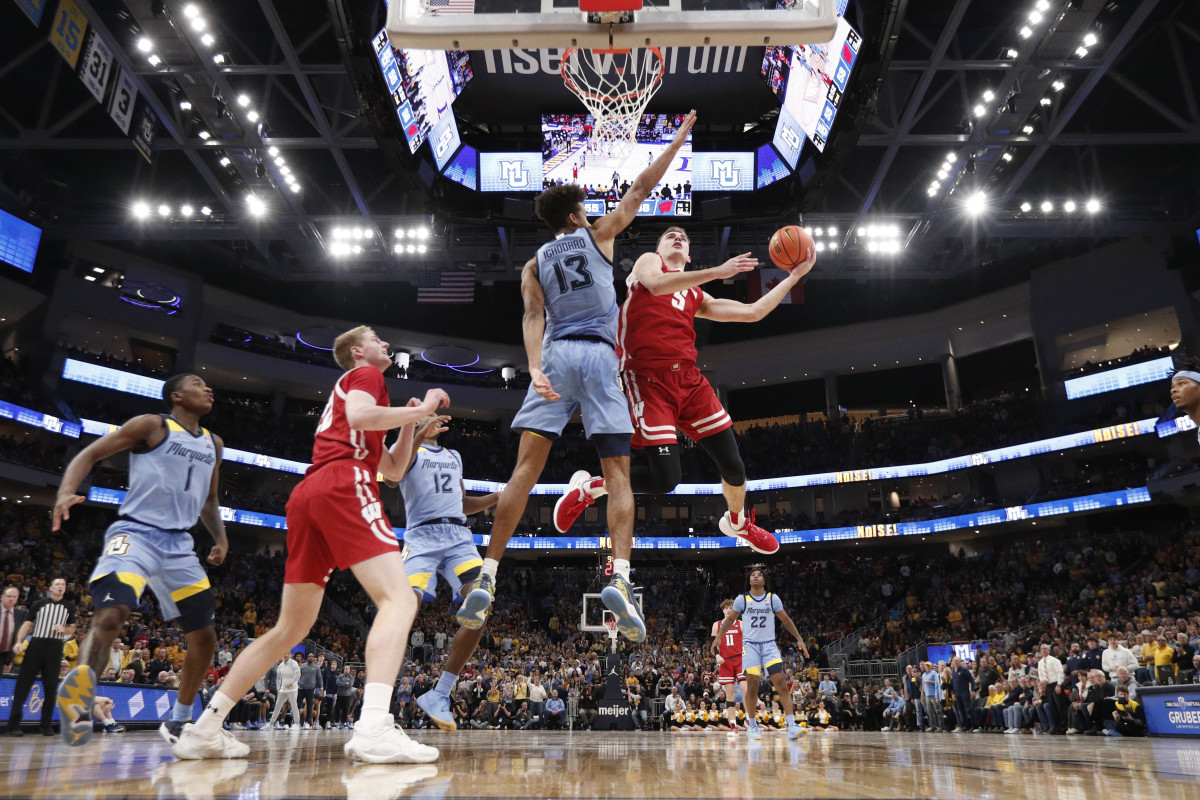 Dec 3, 2022; Milwaukee, Wisconsin, USA; Wisconsin Badgers forward Tyler Wahl (5) shoots around Marquette Golden Eagles forward Oso Ighodaro (13) during the second half at Fiserv Forum. Mandatory Credit: Jeff Hanisch-USA TODAY Sports